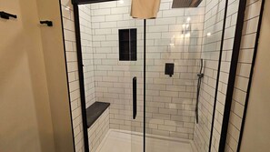 A glass-enclosed shower with white tiles and black fixtures. - Fernie - Timberline Lodges Spruce #236 (Fernie)
