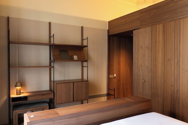 A modern room with built-in wooden shelving, a desk, and a bed. - Mercer Madrid (Madrid)