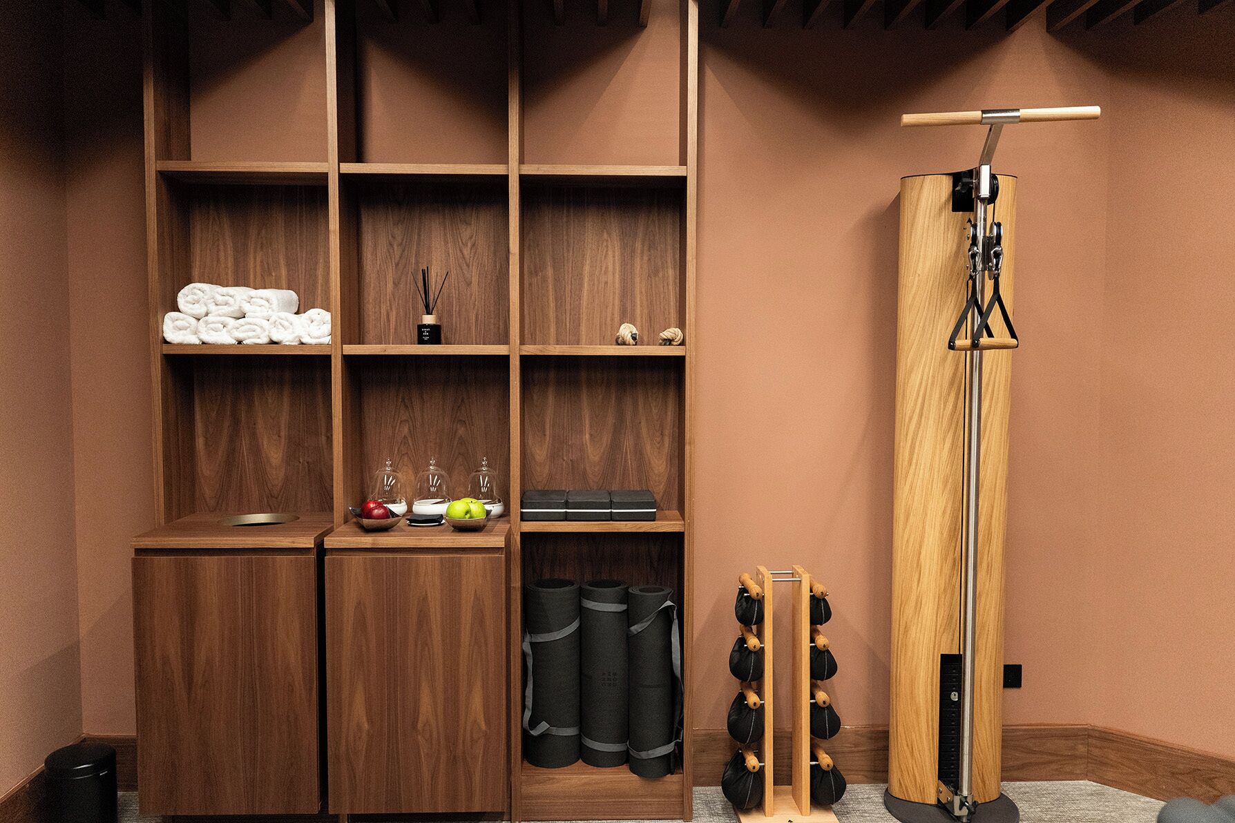 A wooden storage unit with shelves, a shoe rack, and a wooden pole with a hook.