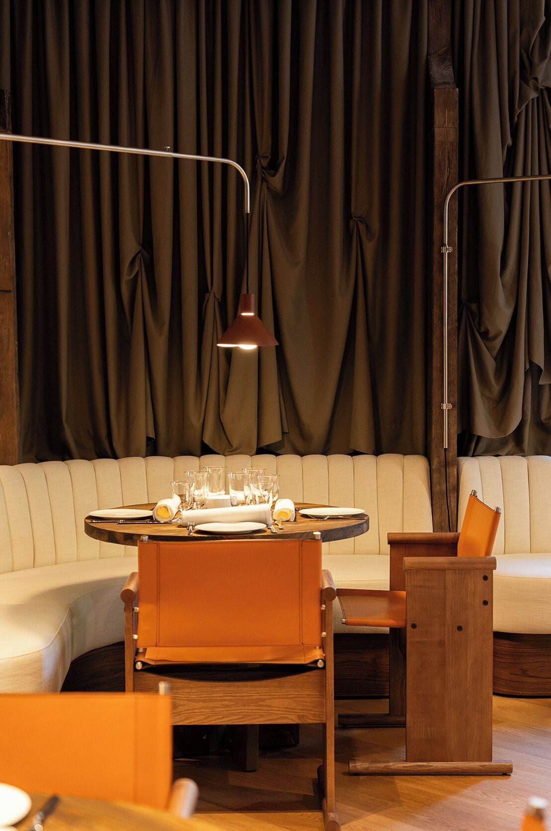 A dining area with a round table set for four, a sofa, and a wooden side table.