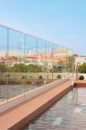 A modern building with a glass facade overlooking a cityscape. - Mercer Madrid  (Madrid)