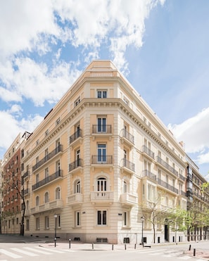 A multi-story building with a classical architectural style, featuring balconies, large windows, and a corner location. - Mercer Madrid  (Madrid)