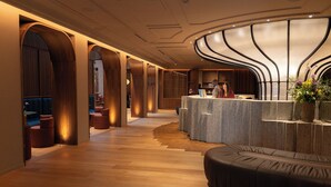 Een hotel lobby met houten vloeren, een receptiebalie en een zithoek.