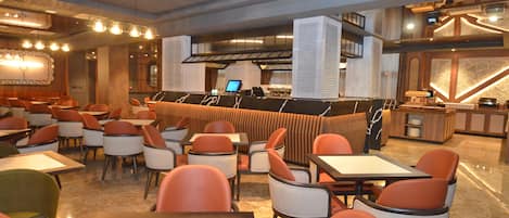 A restaurant with a bar area, multiple seating options including booths and tables, and a modern interior design.