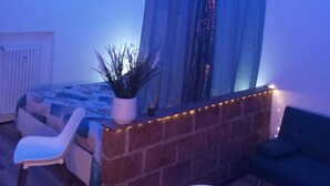 Un salon moderne avec une cheminée en briques, un canapé, une table à manger et une plante en pot.
