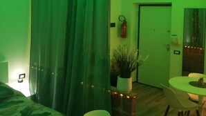 Une pièce avec un lit, une table à manger et un plafond éclairé de lumière verte.