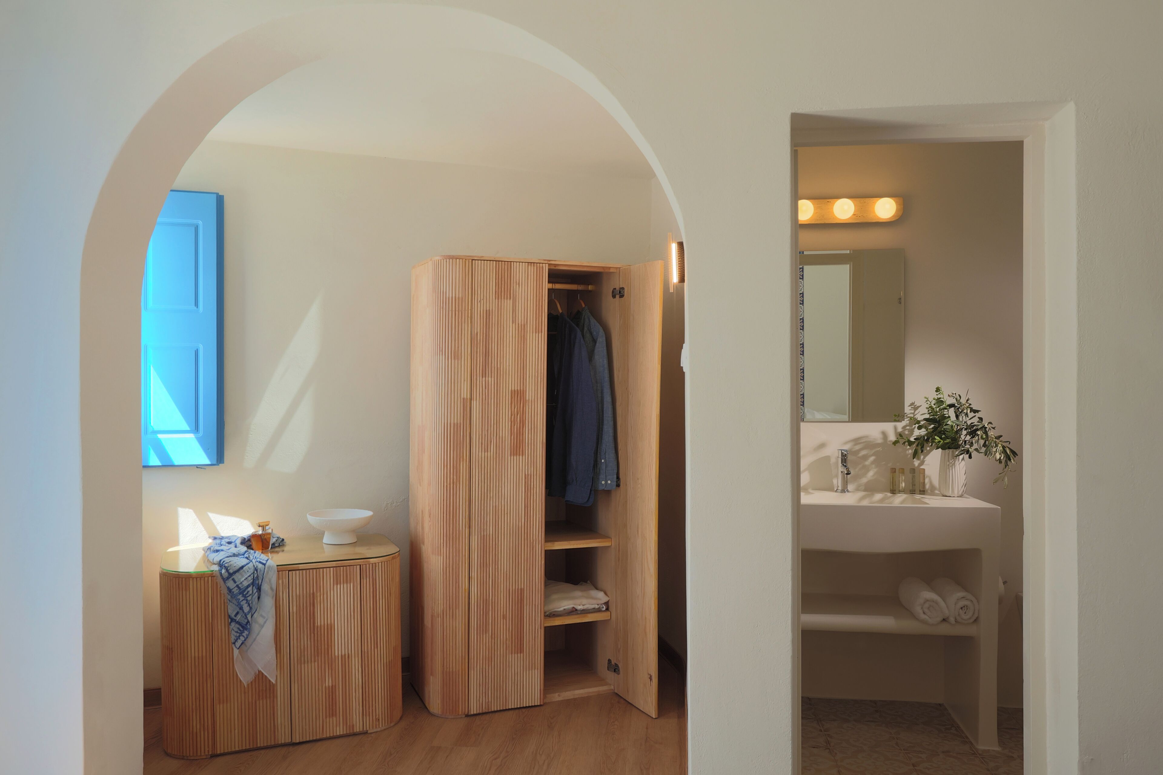 Un baño con tocador de madera, un espejo y un lavamanos.