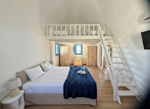 A bedroom with a bed, bedside tables, a tray of items, a wooden wardrobe, and a staircase. - White Pearl Laokasti Suites (Oia)