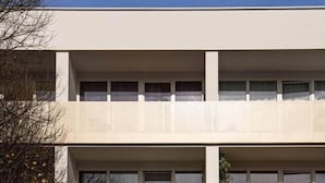 Ein mehrgeschossiges Gebäude mit flacher Fassade, großen Fenstern und einheitlichem Design.