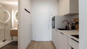 A modern kitchen with white cabinets, a built-in oven, and a sink.