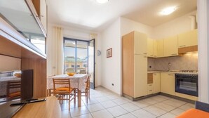 Une cuisine compacte avec un coin repas, un téléviseur et une vue par la fenêtre.