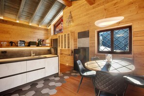 A wooden interior with a kitchen, dining area, and a window with a view.
