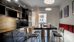 A modern kitchen with a large island, bar stools, and pendant lighting. - RentPlanet - Jedności Narodowej (Wrocław)