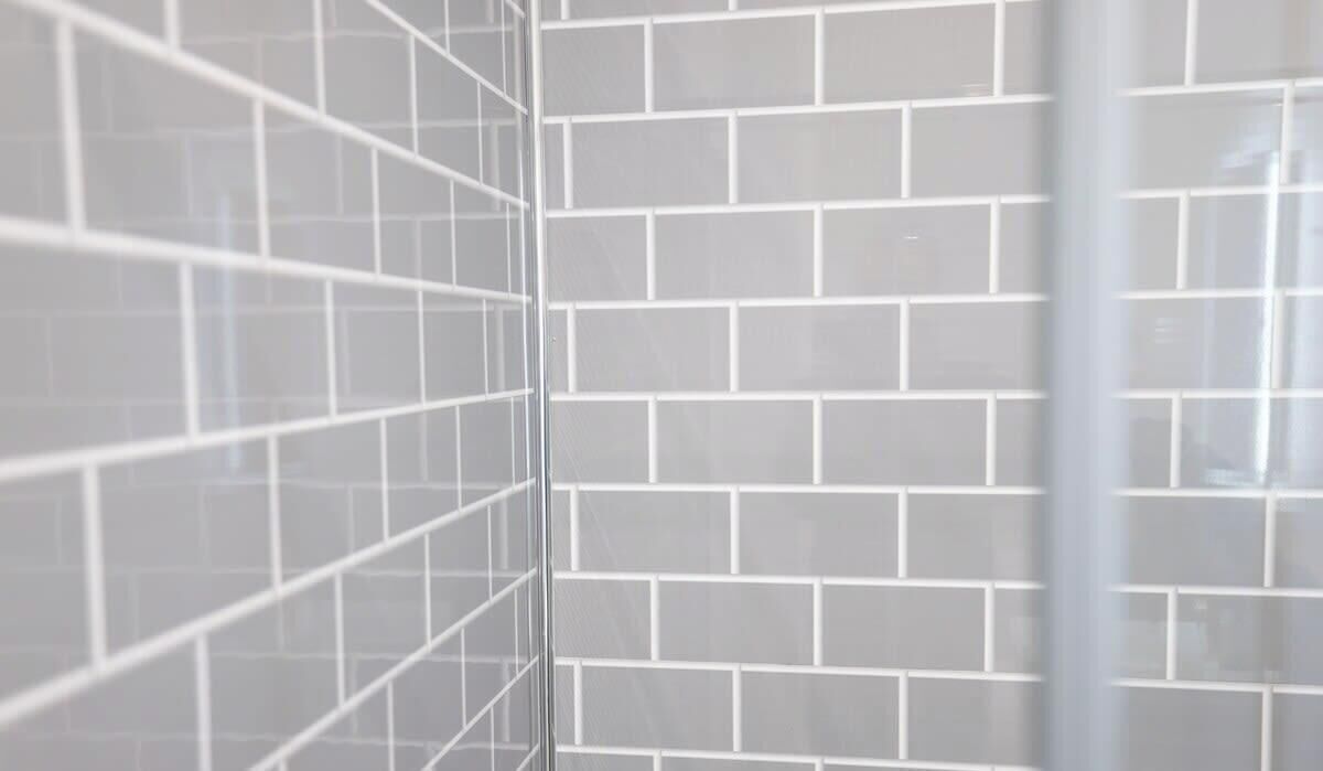 Un mur recouvert de carreaux disposés en motif quadrillé.