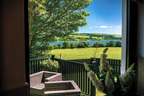 A balcony with a view of a lake and green landscape. - Spacious 4BR with River View & Quiet Garden (Newbuildings)