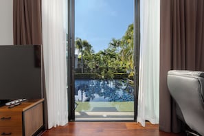 A room with a view of a swimming pool, a television, and a leather sofa. - Aroha Villa Private Pool Nai Harn Beach (Rawai)