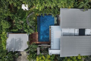 An aerial view of a residential property with a swimming pool, surrounded by lush greenery and a metal roof. - Aroha Villa Private Pool Nai Harn Beach (Rawai)