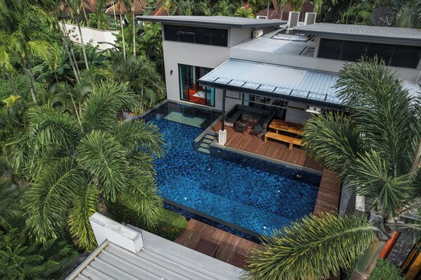 A modern house with a swimming pool surrounded by lush greenery. - Aroha Villa Private Pool Nai Harn Beach (Rawai)