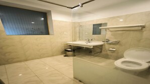 Un bagno moderno con box doccia in vetro, lavabo con specchio e toilette.