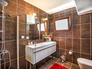 A bathroom with a shower, sink, mirror, and toilet. - mit Blick auf das Wasser by Interhome (Kalkan)