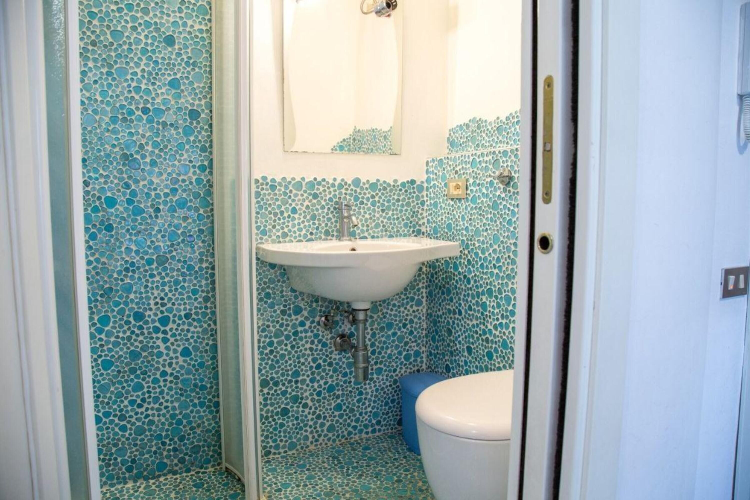 Une salle de bain avec un lavabo, des toilettes et un miroir.