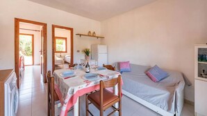 A compact room with a dining area, a bed, and a kitchenette. - Perfectly located flat in San Teodoro (San Teodoro)