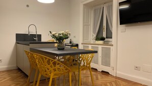 Eine moderne Küche mit schwarzem Arbeitsplatz, gelben Stühlen und einem Blumenstrauß.