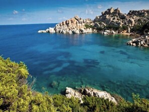 A coastal landscape with clear blue waters, rocky terrain, and dense greenery. - Comfortable family accommodation (Santa Teresa Gallura)