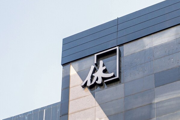 A building facade with a large, modern sign featuring Chinese characters. - Hotel Hue (Incheon)