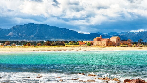 A coastal scene with a beach, clear turquoise waters, and mountains in the background. - Modern house in a peaceful residence (Pula)