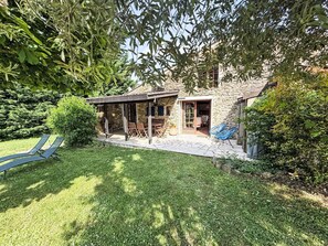 A stone house with a patio, outdoor seating, and a lawn. - GITE im Herzen der Drôme Provençale by Interhome (La Begude de Mazenc)