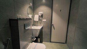 Un baño pequeño con inodoro, lavamanos y espejo.