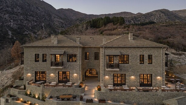 A two-story stone building with a courtyard, large windows, and outdoor seating. - Oreno Mountain Retreat Hotel (Zagori)