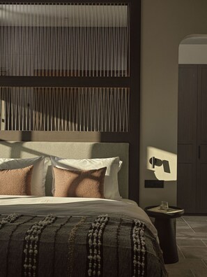 A modern bedroom with a bed, pillows, a bedside table, and a wardrobe. - Oreno Mountain Retreat Hotel (Zagori)