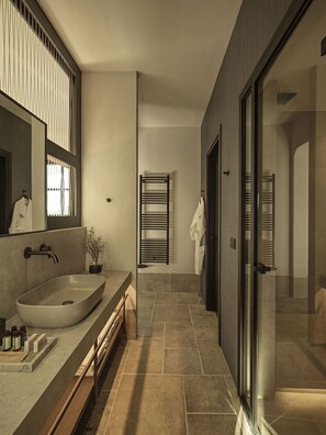 A modern bathroom with a large vessel sink, a mirror, and a glass shower enclosure. - Oreno Mountain Retreat Hotel (Zagori)