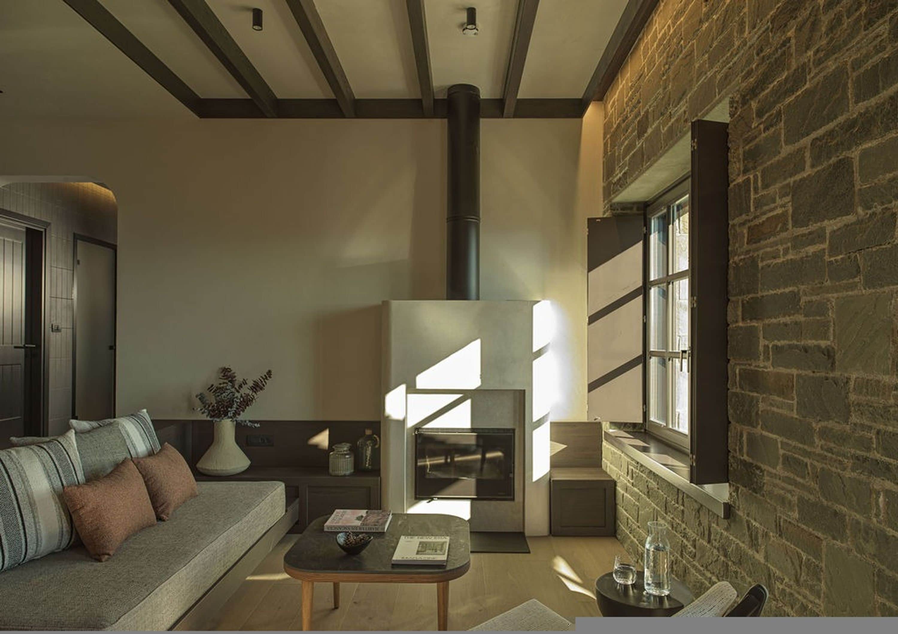 Una sala de estar acogedora con chimenea, un sofá y una mesa de centro.