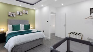 Una camera da letto moderna con un letto, comodini e un appendi asciugamani a parete.