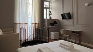 A hotel room with a bed, a desk, a chair, a TV, and a window with curtains. - Turin Central Cavour (Turin)
