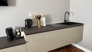 A modern kitchen with a black countertop, a sink, and a coffee maker. - Turin Central Cavour (Turin)