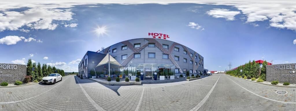 A large, modern hotel with a curved facade, multiple windows, and a prominent "HOTEL" sign.