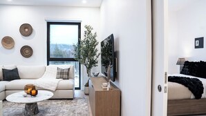 Una sala de estar moderna con un sofá, una mesa de centro y un ventanal grande.