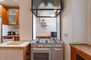 Une cuisine équipée d’une cuisinière à gaz, d’un four à micro-ondes et d’un lave-vaisselle.