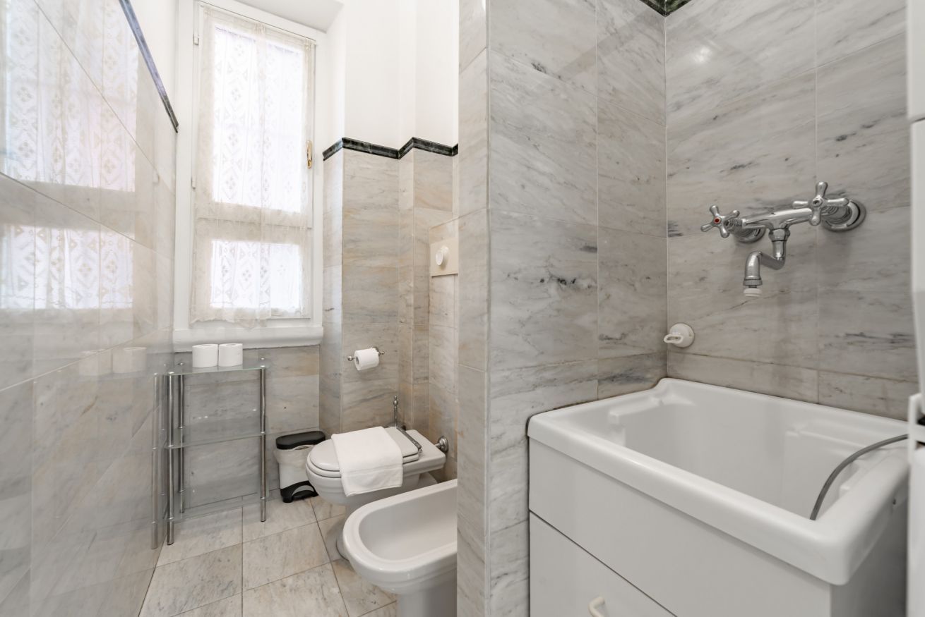 Ein modernes Badezimmer mit Badewanne, Toilette, Bidet und einer Duschkabine aus Glas.