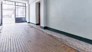 A hallway with a tiled floor, white walls, and a door leading outside. - Charmant Studio II au coeur de Vincennes (Vincennes)