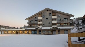 A multi-story hotel with a ski slope in the background. - Juracîmes Duo apartment for 2 people (Mijoux)