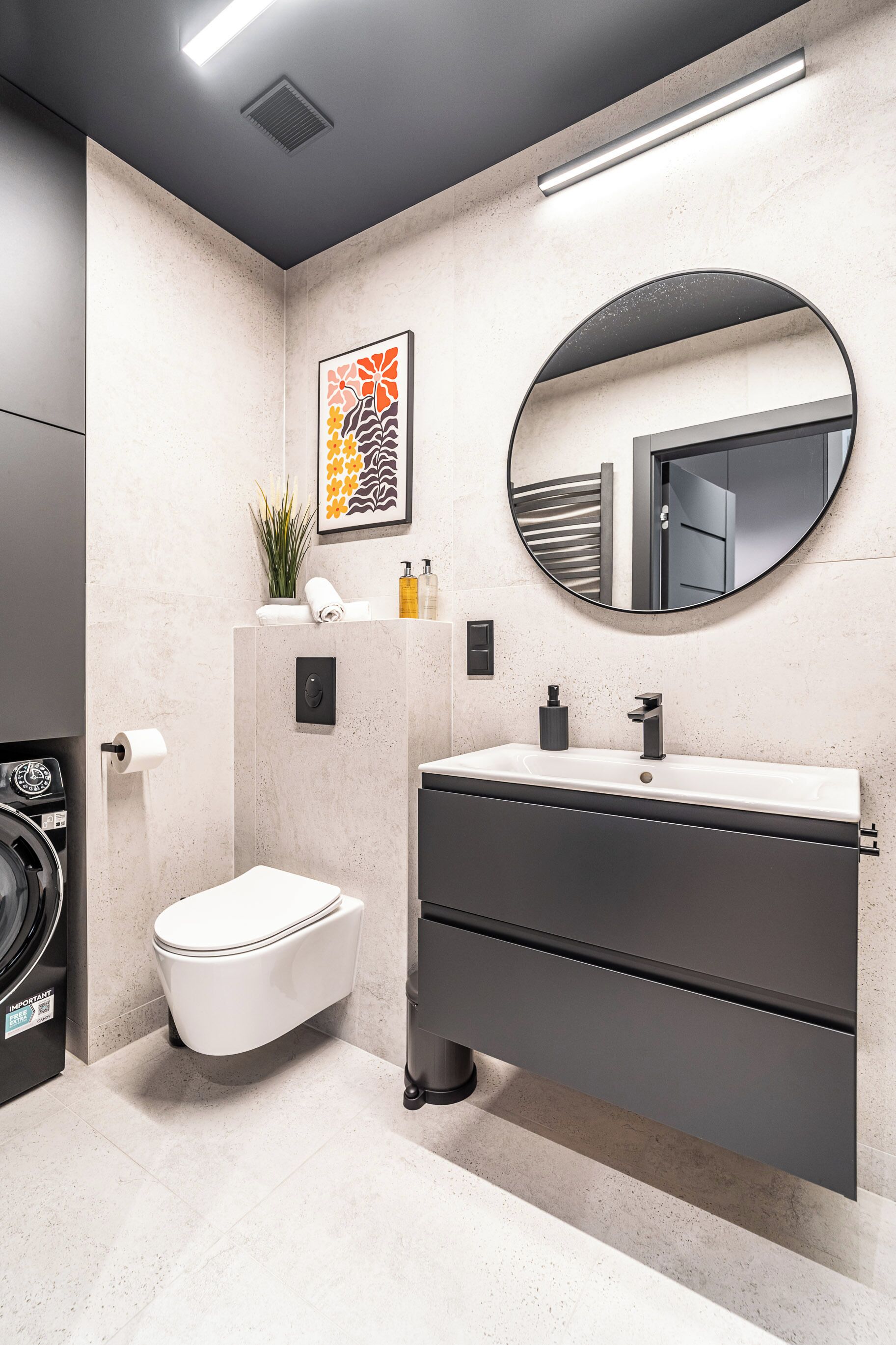 A modern bathroom with a toilet, sink, and mirror.