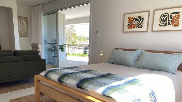 A modern bedroom with a large bed, a sofa, and a view of the outdoors. - Suite Milton - Quiet stylish studio in the heart of town, ideal couples getaway. (Milton)