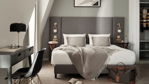 Un dormitorio moderno con cama, mesitas de noche, escritorio y silla.
