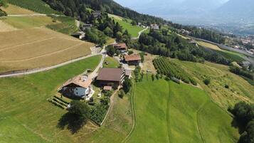 Vista aérea de uma aldeia rural com casas, campos e uma estrada.