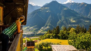 A wooden cabin with a view of mountains and a valley.